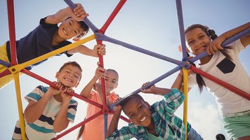 portrait of happy schoolkids looking through dome climber